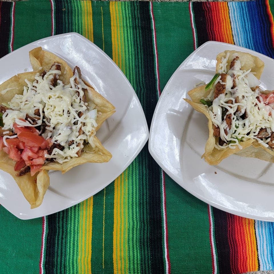 Two Fiesta Mexican Restaurant taco salads in crispy tortilla bowls with meat, cheese, and tomatoes.